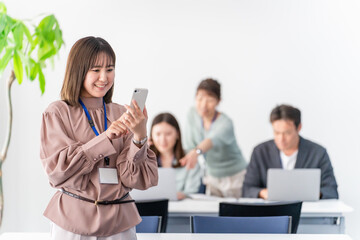 オフィス・会議室でスマホを操作するビジネスウーマン・女性
