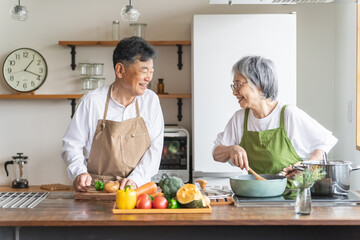 家のキッチンで一緒に料理・家事を楽しむ高齢者夫婦・シニアカップル
 - obrazy, fototapety, plakaty