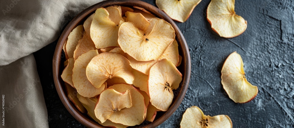 Poster fresh and nutritious sliced apples in a bowl on a rustic wooden table