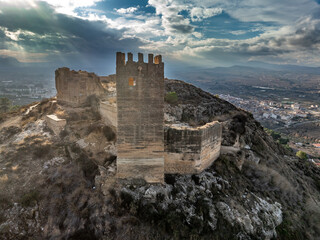 Fototapeta premium Aerial view of Pliego town and medieval castle in Southern Spain, ruined walls made of rammed earth with Arab origin