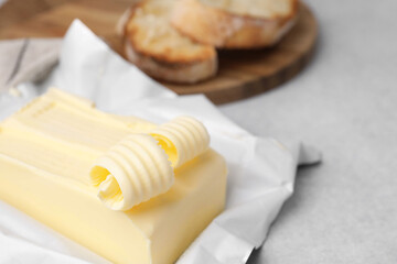 Tasty butter and curls on light grey table, closeup