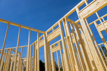 Wood frame of new house during construction, framed by timber wood stick frames