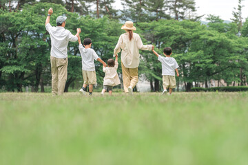 夏休みに公園を手を繋いで歩く家族・ファミリー（レジャー・アウトドア・ピクニック・キャンプ・思い出）
 - obrazy, fototapety, plakaty