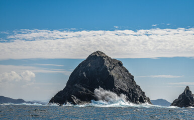 Mar rompiendo. Isla de roca y montaña. 