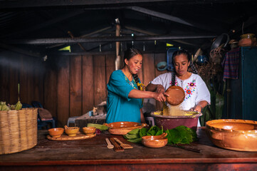 Latina woman adds sugar to the mixture that will be used to make sweet corn tamales.