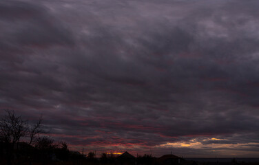 Obraz premium Landscape at sunset. Tragic gloomy sky. Panorama. Crimson twilight.
