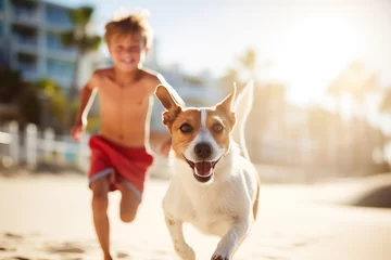 Foto op Canvas A boy with a dog running on the beach © Doggie Portraits
