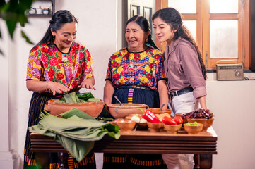 Portrait of three women, three generations, grandmother mother and daughter preparing Guatemalan tamales.