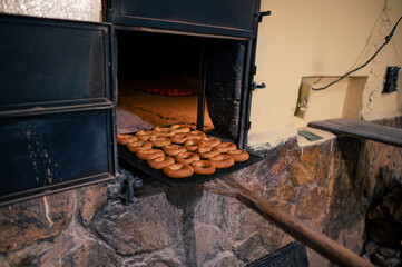 Cookies on a metal tray in the door of a handmade oven.