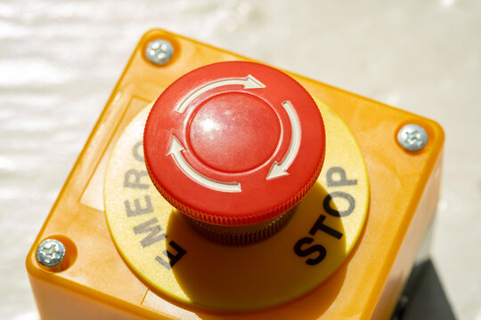 A red Emergency STOP button used for safety on industrial equipment, machine machinery electrical system emergency shutdown mechanism, nuclear power plant, factory, workers safety security concept