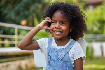 Portrait happy african american cute girl smiling face looking and think at home, kid, child, young adorable, student, elementary school and education concept