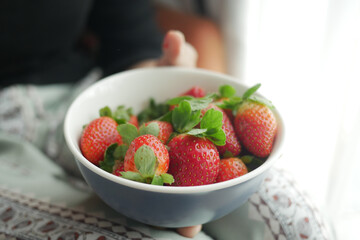  women holding a bowl of Ripe Red Strawberries 