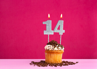 Birthday cupcake with candle number 14 - Birthday card on pink background