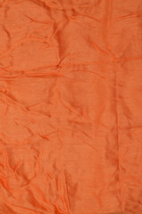 Orange crumpled textile background.