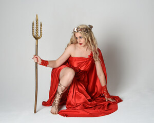 Full length portrait of beautiful blonde model dressed as ancient mythological fantasy goddess in...