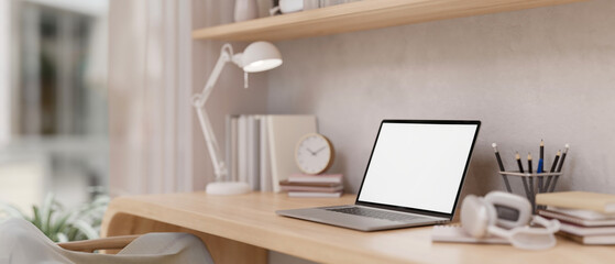 A minimal Scandinavian beige home office workspace with a laptop mockup and decor on a wooden table.
