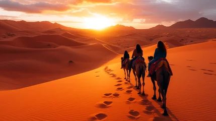 Foto op Plexiglas A group of people ride camels across the desert during a beautiful sunset. © weerasak