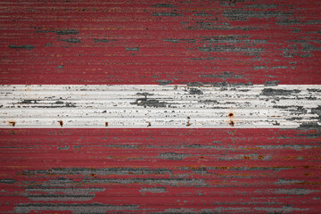 Close-up of old metal wall with national flag of Latvia. Concept of Latvia  export-import, storage...