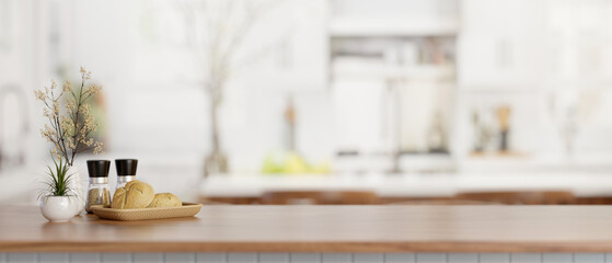 A bread basket, spice bottles, and a copy space on a wooden kitchen countertop in a modern kitchen.