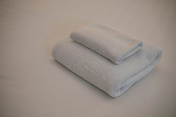A white towel is placed on the bed.