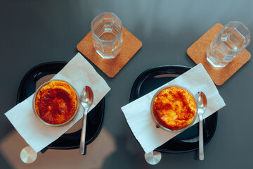 Two Homemade Souffle Meals with Water Glasses on a Table. Delicious romantic dinner freshly baked 
