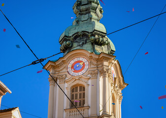 Part of the clock tower of the Parish Church of the Holy Blood in Graz, Austria against a blue sky