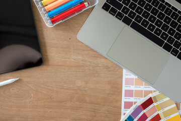 Top view of the designer workspace with essential elements on wooden table