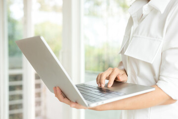 Businesswoman standing and using a laptop at office