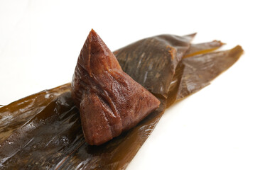 Zongzi, the traditional sticky rice dumpling unwrapped from its leaves, isolated on a white background.