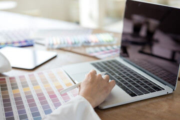 Graphic designer using color swatch to do his work at modern office. Architect using work tools and...