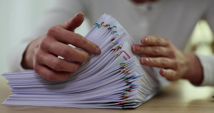 Businesswoman hands work in stacks of paper files to search for information in office on desktop