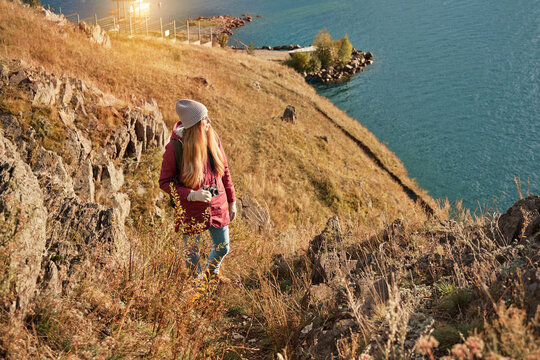 Woman walking alone with scenic view of the lake on the cliff