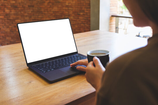 Mockup image of a woman working and typing on laptop computer with blank white desktop screen at home