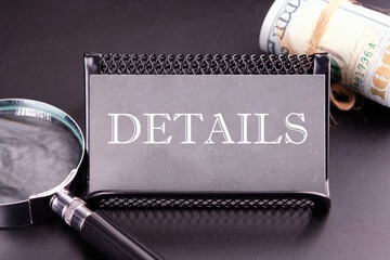DETAILS text on the business card next to the money, a magnifying glass on a black background