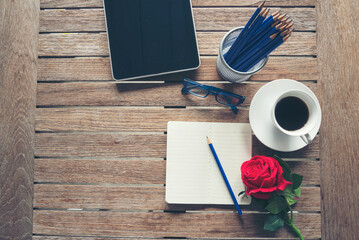 Top view office desk smart tablet document paper, coffee cup roses on wood table with copy space....