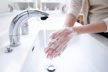 石鹼で手を洗う女性の手元