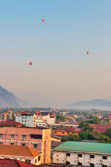 19022024 Colorful hot air balloons fly over the Vang vieng city, Laos in Asia. This was during sunrise on a clear hot day during dry season.