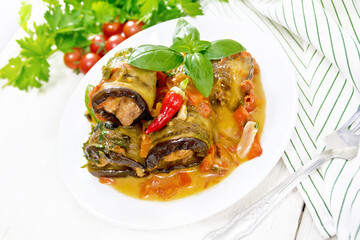 Rolls of eggplant with mincemeat in plate on white board