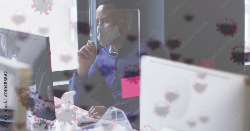 Poster image of virus cells over businessman with face mask using computer in office
