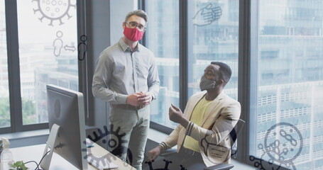 Image of virus icons over diverse businessmen with face masks talking in office