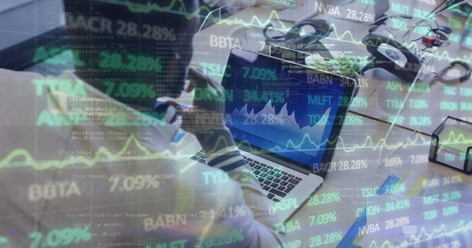 Image of financial data processing over businessman with face mask using laptop in office