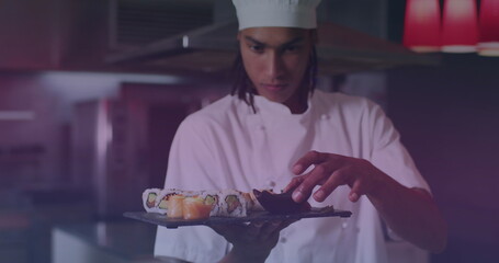 Image of biracial male chef preparing sushi