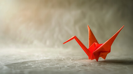 Fototapeta na wymiar Red origami crane on textured paper.