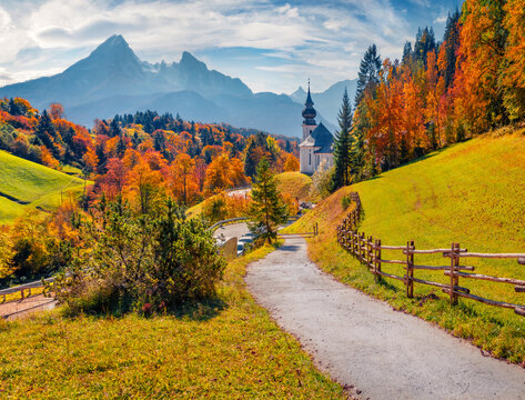 Iconic picture of Bavaria with Maria Gern church with Hochkalter peak on background. Sunny autumn scene of Alps. Stunning landscape of Germany countryside. Traveling concept background.