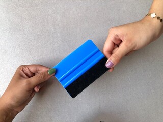 hand holding a blue scrapper