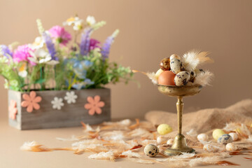 Easter composition with eggs, feathers, and spring flowers.