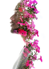 A double exposure profile portrait of a man combined with pink flowers