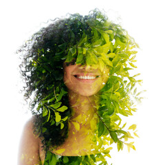 A double exposure portrait of a young woman with frizzy hair merged with leaves - 740499639