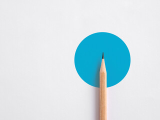 Minimalist template of a wooden pencil on a blue circle on white background. Abstract minimal design.