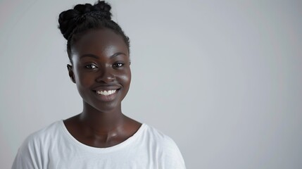 Obraz premium Smiling positive female with attractive look wearing loose white Tshirt posing against white blank wall Happy woman with hair bun showing positive emotions after receiving pleasant com : Generative AI